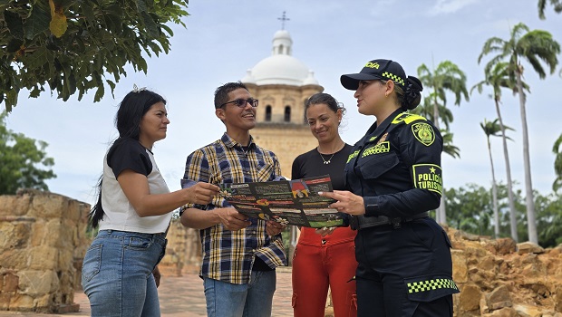 Tres personas recibiendo gu&iacute;a de turismo de una funcionaria de la polic&iacute;a