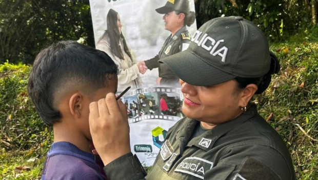 policía comunitaria realiza pintucaritas  a un niño
