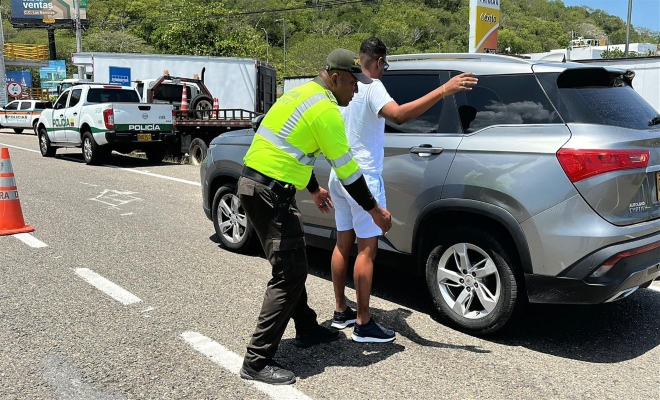un policía realizando un registro aun civil y un vehículo 