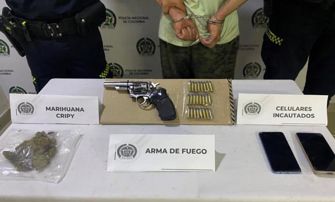 Vista parcial del capturado esposado y las evidencias del procedimiento.