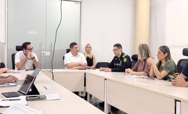 grupo de personas en rueda de prensa junto con dos policías uniformados