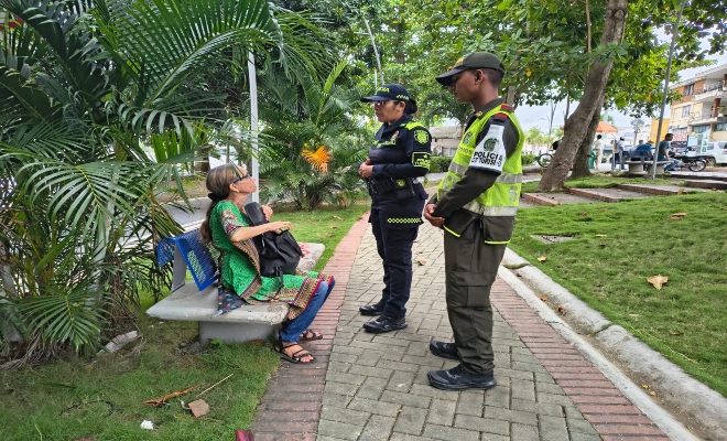 dos uniformados realizando charla  a una ciudadana en el parque principal de la ciudad de Montería