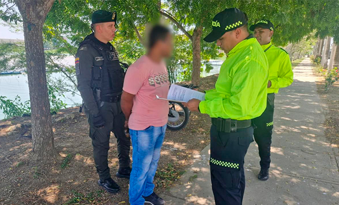 Funcionario de Policía Judicial realiza lectura de derechos de capturado a hombre capturado.