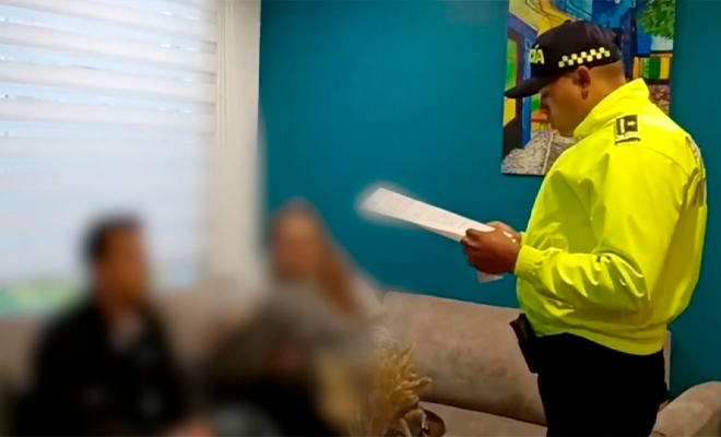 Funcionario de Policía Judicial realiza lectura de derechos de capturado a hombre capturado.