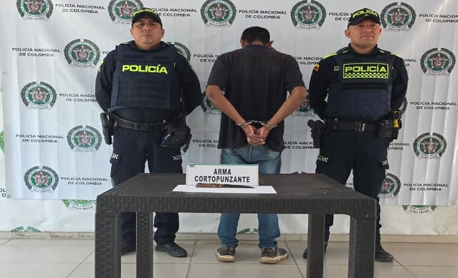Dos policías con un capturado y un elemento incautado