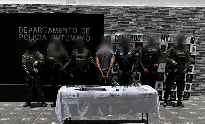 Policía, GAULA Militar y CTI junto a sujeto capturado y elementos incautados frente a una mesa