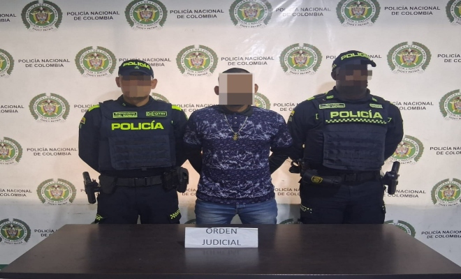 Dos uniformados con una persona capturada por el delito tráfico, fabricación o porte de estupefacientes