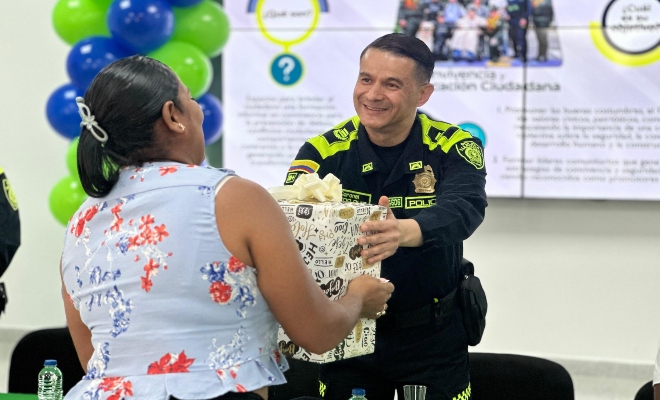 Coronel Héctor Ruiz Arias Haciendo entrega de un obsequio a una participantes de los espacios pedagógicos