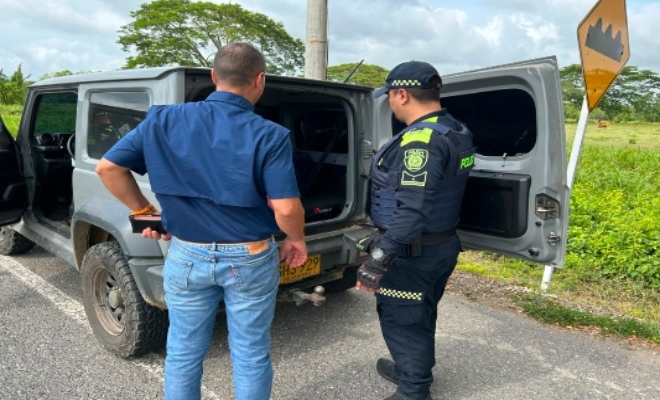 Un uniformado de la Policía Nacional junto a un ciudadano, durante el registro de su vehículo en el marco de los planes de control que realiza la institución