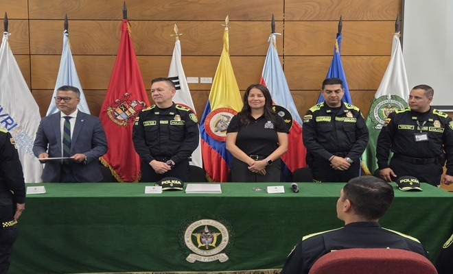 Cuatro personas en una mesa con una mujer para entregar los diplomas