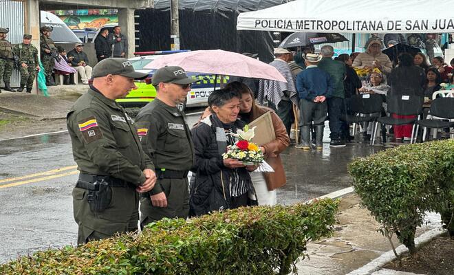 Dos policias y dos madres honrando la memoria de los integrantes de la institución