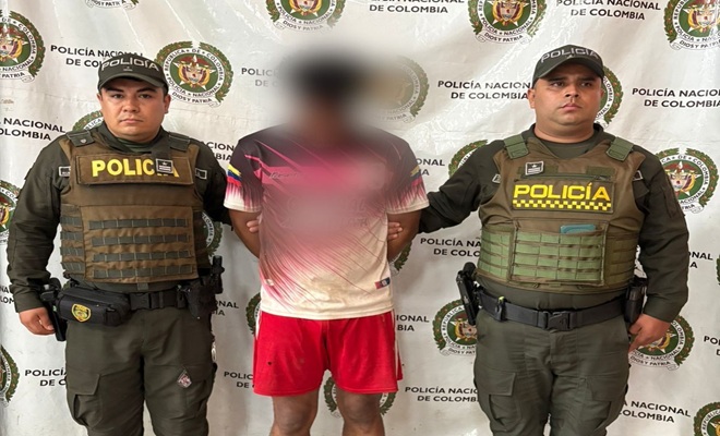 Dos polic&iacute;as custodiando el capturado por homicidio