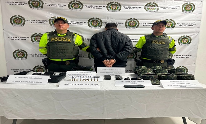 Dos policías de tránsito custodiando un capturado, armamento y prendas militares