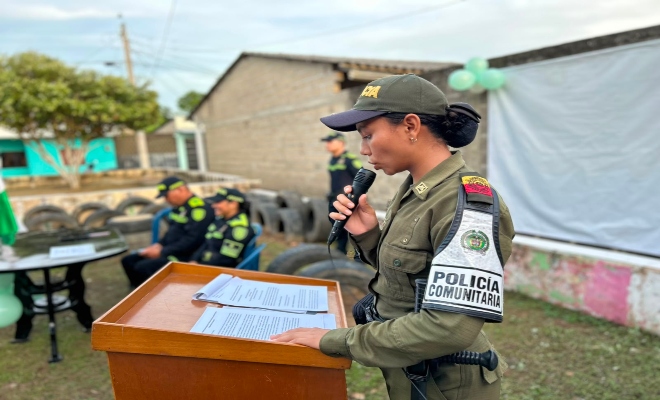 funcionaria policial realizando la lectura de un acta dirigiéndose a la comunidad