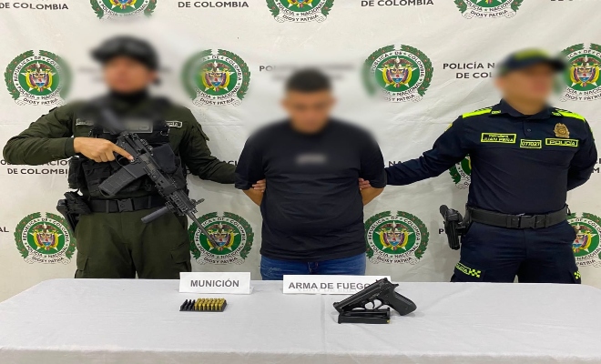 dos uniformados de la Policía nacional con una persona capturada por el delito de porte ilegal de armas de fuego.