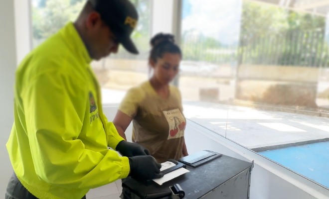Policía realizando enrolamiento de huellas a una persona capturada