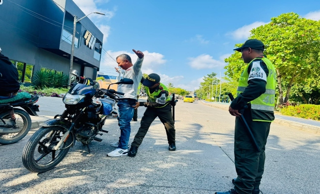 dos uniformados de la policía nacional  realizan registro a un ciudadano  en vía principal 