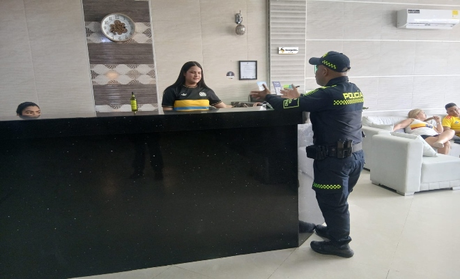 un uniformado de la policía  Nacional y una ciudadana  realizando registro a hoteles  en  la ciudad  de montería    