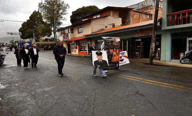 Madres caminando por la calle con la foto de sus hijos policias
