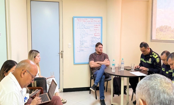 un uniformado con varias personas en una mesa redonda dialogando