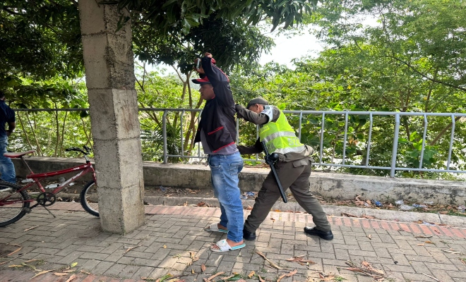 un uniformado realizando registro a un ciudadano 