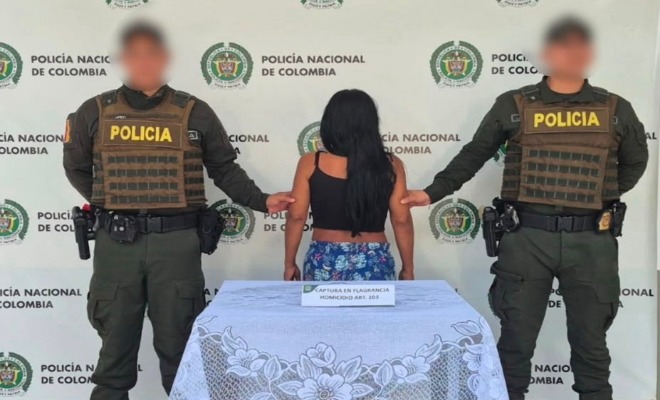 Dos policías agarrando de los brazos a una mujer capturada 