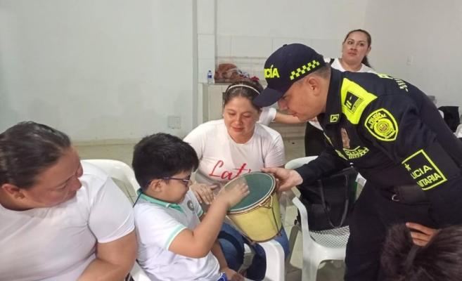Niño en compañía de policía tocando instrumento musical 