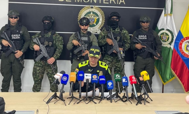 Señor comandante de la Policía Metropolitana de Montería en rueda de prensa con tres funcionarios de policía al fondo y dos mas del ejercito nacional 