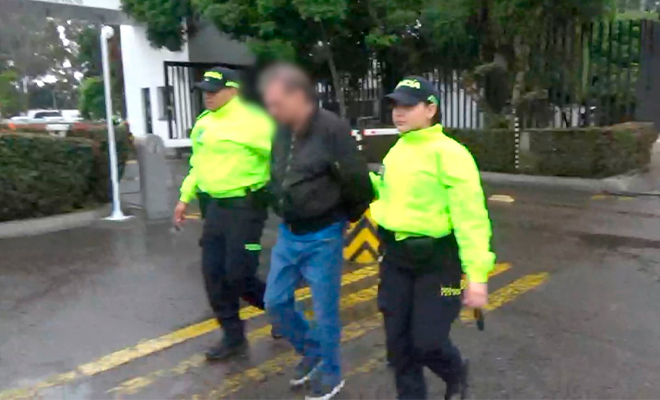Dos policías se desplazan con un capturado.