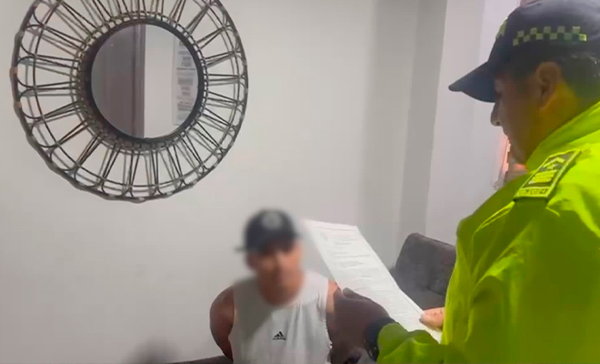 Funcionario de policía judicial realiza la lectura de derechos de capturado a sujeto, en el marco del ala operación Thunder II. 