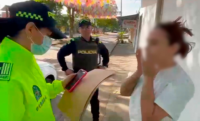 Funcionario de policía judicial realiza la lectura de derechos de capturado a mujer, en el marco del ala operación Thunder II. 