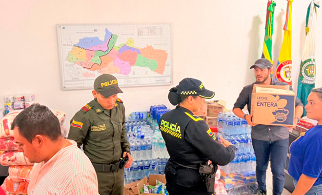 Polic&iacute;a Nacional y comunidad organizando las ayudas de elementos de la canasta familiar