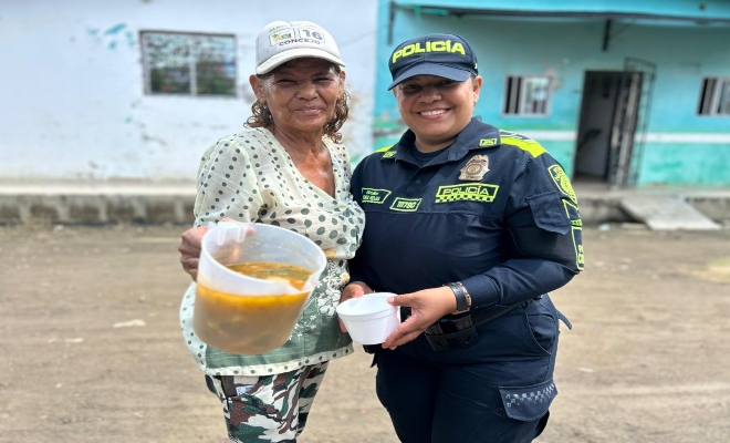 una uniformada de la policía nacional con  una ciudadana compartiendo comida