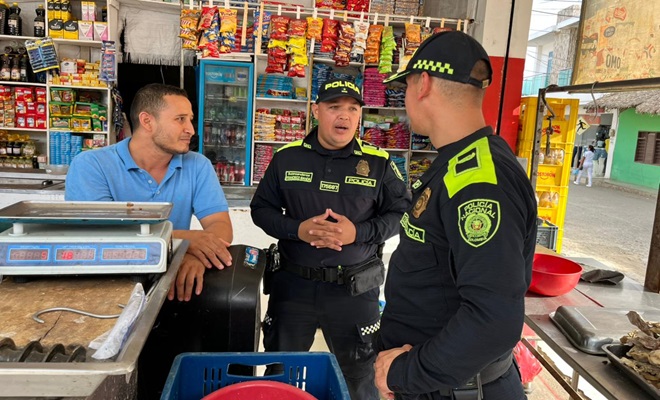 Dos funcionarios policiales dialogando con un tendero