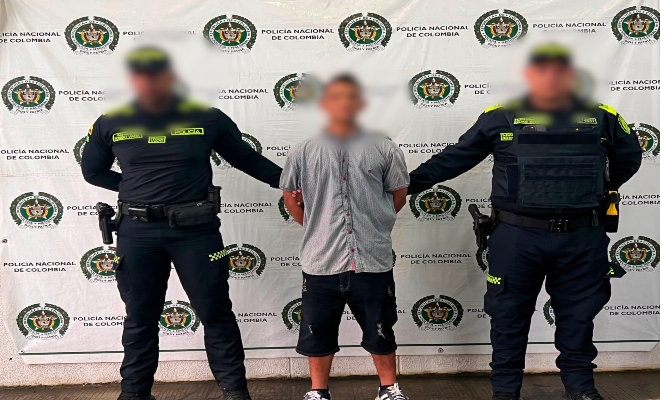 Dos uniformados con una persona capturada por el delito violencia intrafamiliar.