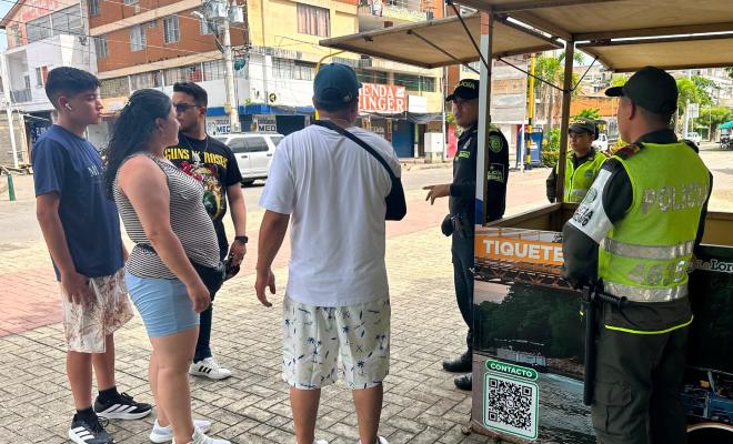 tres uniformados de la Policía nacional con cuatros ciudadanos  recibiendo recomendaciones en el centro de la ciudad  