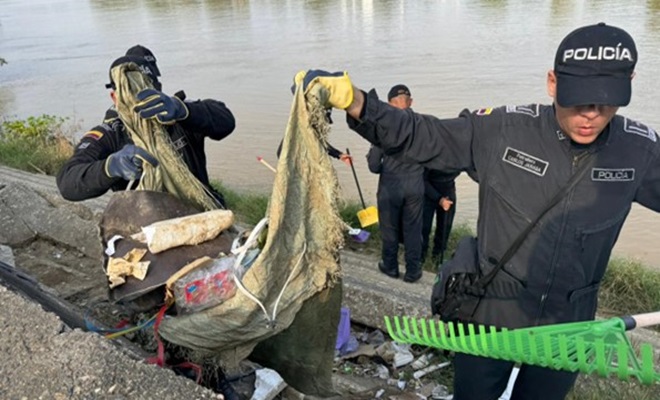 Policías recogiendo basuara a orillas del río