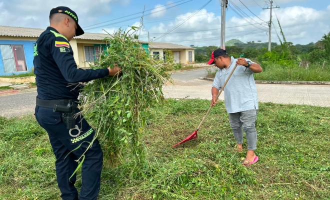 Funcionario policial con ciudadano realizando actividades de ornato en actividad de recuperación de espacio público 