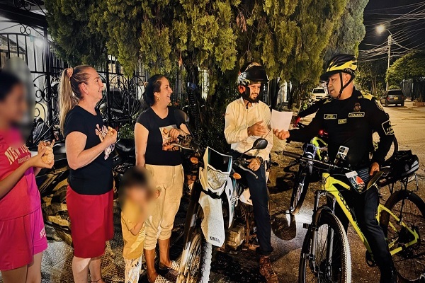 Policía de patrulla purpura entregando volantes informativos a cuatro ciudadanos