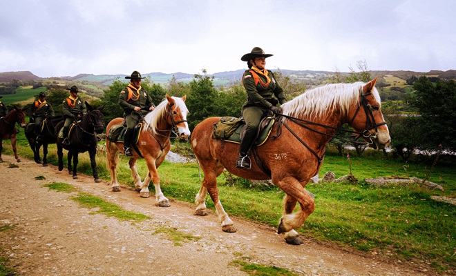 Policias carabineros montan caballo en la zona rural