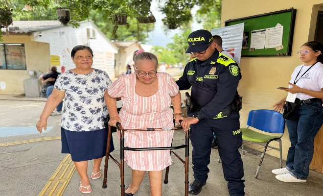 dos ciudadanas de avanzada  edad  acompañadas por un uniformado 