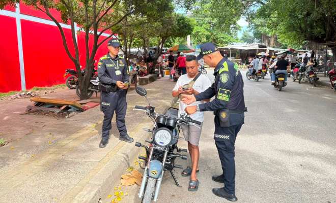 Dos funcionarios policiales con un ciudadano verificando sus antecedentes