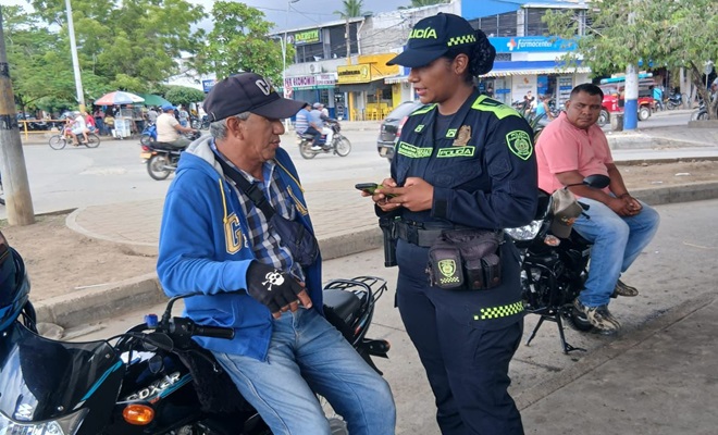 Una funcionaria policial dialogando con un ciudadano en v&iacute;a p&uacute;blica