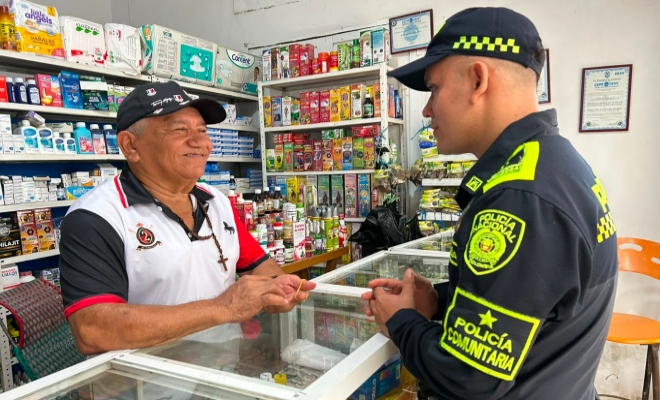 Funcionario policial de grupo de policía comunitaria brindando recomendaciones a un señor comerciante