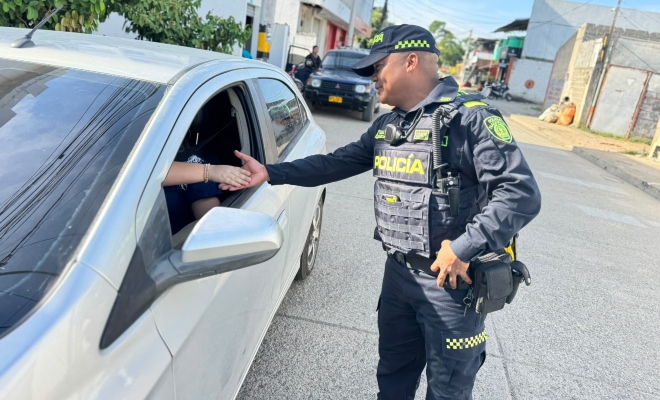 Funcionario policial con ciudadano dentro de un vehículo saludándolo