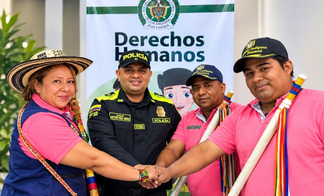 Funcionario policial uniendo puños con tres representantes del Cabildo Indígena Finzenú