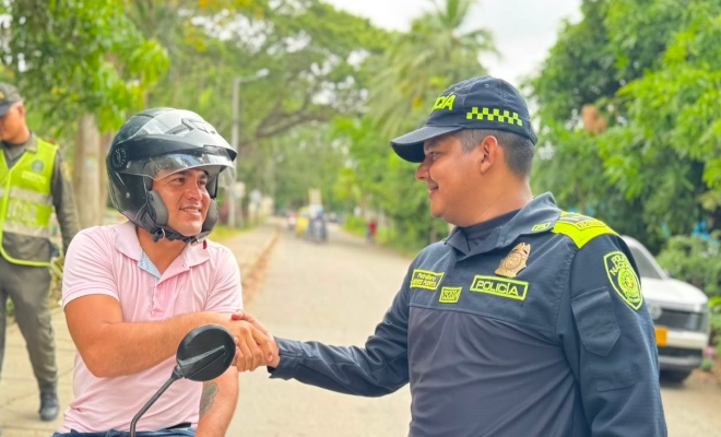un funcionario policial saludando a una ciudadana en vía principal del municipio de cereté