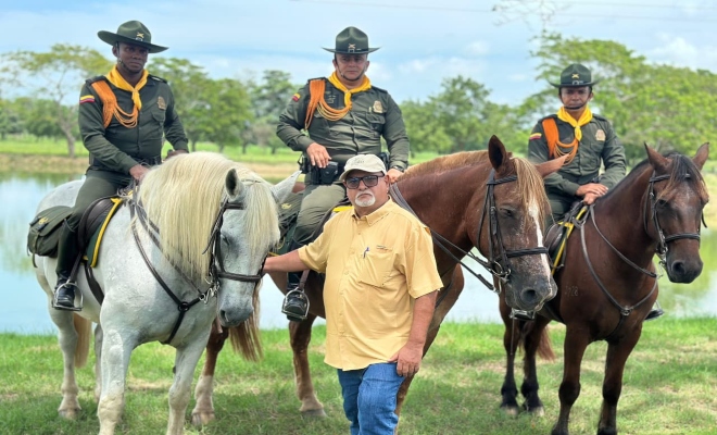 tres funcionarios policiales de carabineros en sus respetivos caballos junto a un adulto mayor mirando a la cámara 