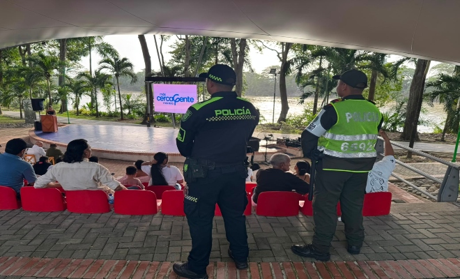 dos uniformados  de la policía nacional con varias personas en un establecimiento abierto al publico  