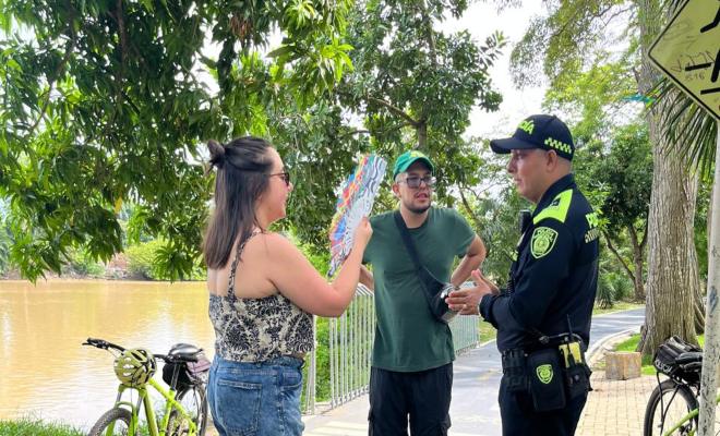 Uniformado policial saludando a dos ciudadanos en actividades preventivas en la Ronda del Sinú